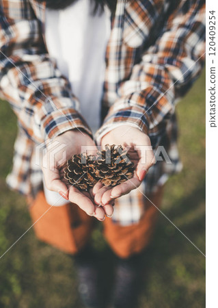 Woman holding a pine cone Woman holding a pine cone 120409254