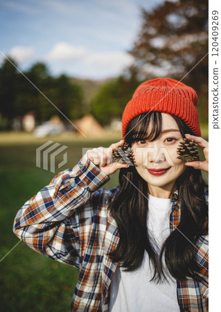 Woman holding a pine cone Woman holding a pine cone 120409269