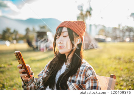 坐在露營地聽音樂的女人 120409576