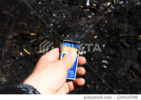 Setting fire to a picnic fire . Burning matches in hands 120410706