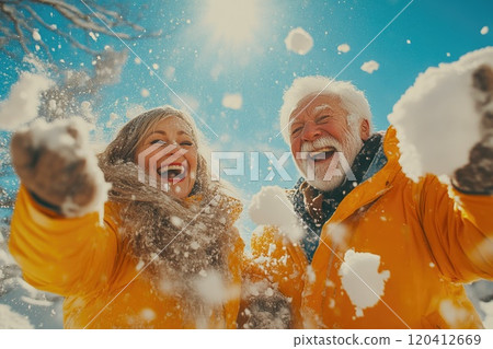 Happy Elderly Couple Playing in Winter Snow 120412669