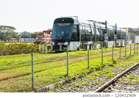 The circular light rail train drives past Hamasen Railway Cultural Park in Kaohsiung, Taiwan. The circular light rail train drives past Hamasen Railway Cultural Park in Kaohsiung, Taiwan. 120412909