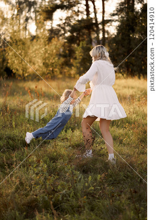 Happy Caucasian mother holding her baby in the air on a walk in a summer park 120414910