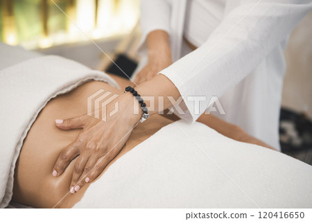Massage process of the abdomen and peritoneal organs in pro salon, close-up. Therapist hand on female body, faceless people, movement, selective focus. 120416650
