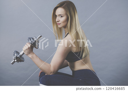 Fit woman lifting dumbbells weights 120416685