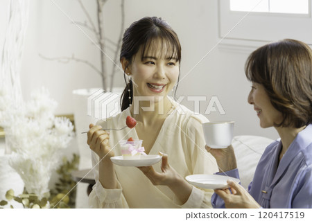 A mother and daughter in their 30s eating sweets at a cafe A mother and daughter in their 30s eating sweets at a cafe 120417519