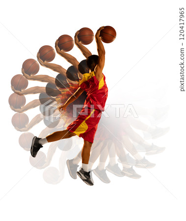 Dynamic photo of basketball player in red and yellow uniform performing powerful dunk. Stroboscope effect highlights action's intensity. 120417965