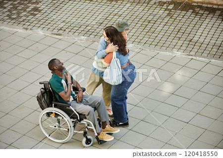 Minimal high angle shot of diverse group of friends meeting in city outdoors with African American man using wheelchair on graphic pavement tiles copy space Minimal high angle shot of diverse group of friends meeting in city outdoors with African American man using wheelchair on graphic pavement tiles copy space 120418550