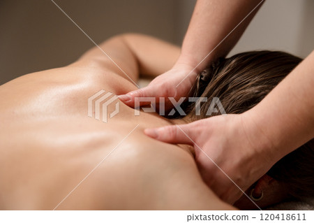 Therapist massaging the shoulder muscles with both hands during a therapy session. Stress relief and wellness concept 120418611