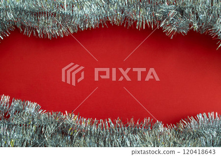 Christmas holiday background with copy space. Tinsel on a red background. Christmas holiday background with copy space. Tinsel on a red background. 120418643