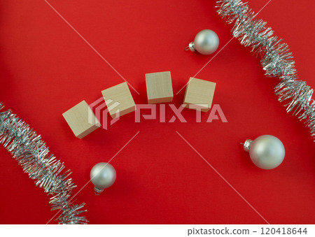 New Year's card template. Wooden cubes for the number of the year, Christmas balls and tinsel on a red background. New Year's card template. Wooden cubes for the number of the year, Christmas balls and tinsel on a red background. 120418644