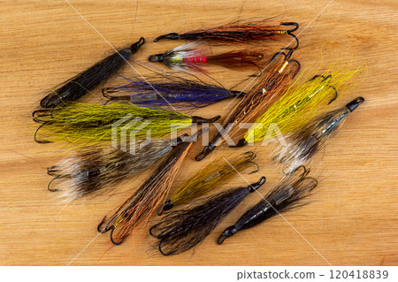 A Pile of Waddington Type Salmon Fishing Flies on a Wooden Table Top 120418839