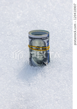 Roll of us dollar banknotes on the snow surface 120418907