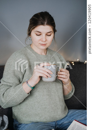 Pregnant woman with warm drink, embracing slow living. Intentional motherhood, self-care, and calm during pregnancy. 120419905