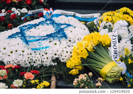 Israeli flag and yellow daffodils on stone steps, symbolizing Holocaust remembrance and national mourning 120419920