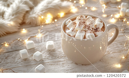 A mug with hot cacao, whipped cream and marshmallows, placed on a white rustic background with white faux fur , with small lighting garland scattered around, creating a cozy and festive atmosphere A mug with hot cacao, whipped cream and marshmallows, placed on a white rustic background with white faux fur , with small lighting garland scattered around, creating a cozy and festive atmosphere 120420372