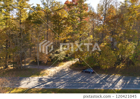 Winding parkway road in colorful mountain forest with yellow canopies in autumn at sunset. Driving in North Carolina wild woods nature in fall season Winding parkway road in colorful mountain forest with yellow canopies in autumn at sunset. Driving in North Carolina wild woods nature in fall season 120421045