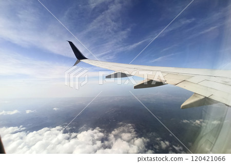 View through airplane window of commercial jet plane wing flying high in the sky. Air travelling concept View through airplane window of commercial jet plane wing flying high in the sky. Air travelling concept 120421066