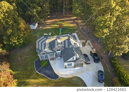 View from above of expensive residential house between yellow fall trees in suburban area in South Carolina. American dream home as example of real estate development in US suburbs 120421083