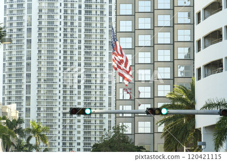 USA national flag waving on wind in front of Miami urban skyline. American stars and stripes spangled banner as symbol of democracy USA national flag waving on wind in front of Miami urban skyline. American stars and stripes spangled banner as symbol of democracy 120421115