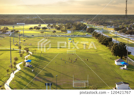Public sports arena in North Port, Florida with school kids playing soccer game on grass football stadium. Outdoor activities concept Public sports arena in North Port, Florida with school kids playing soccer game on grass football stadium. Outdoor activities concept 120421767