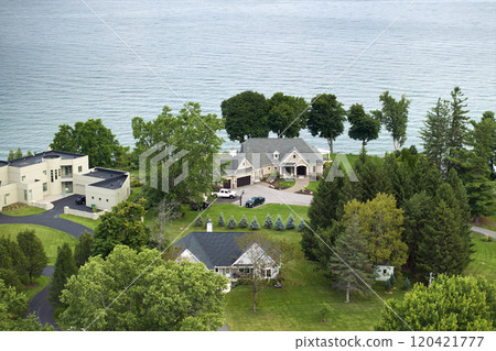 Private residential houses in lakeside suburban sprawl area in Rochester, New York. Upscale suburban homes with large backyard and green grassy lawn in summer season Private residential houses in lakeside suburban sprawl area in Rochester, New York. Upscale suburban homes with large backyard and green grassy lawn in summer season 120421777