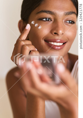 Skin Care Routine. Woman Applying Skincare Cream with Joyful Expression on Her Face 120421778