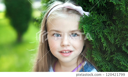 Portrait of happy pretty child girl standing in summer park looking in camera. 120421799