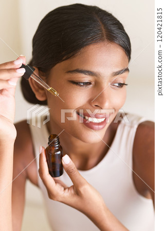 Woman Applying Facial Oil for Skincare and Beauty Routine at Home 120421815