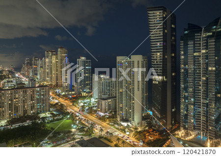 Night urban landscape of downtown district in Sunny Isles Beach city in Florida, USA. Skyline with brightly illuminated streets and high skyscraper buildings in modern american megapolis 120421870