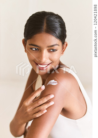 Radiant Woman Applying Skincare Cream Joyfully on Her Shoulder 120421898