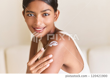 Woman Smiling While Applying Skincare Cream on Shoulder at Home Woman Smiling While Applying Skincare Cream on Shoulder at Home 120421900