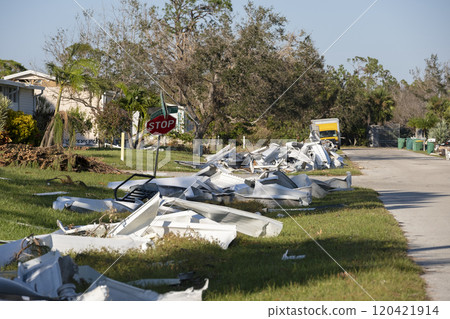 Metallic scrap rubbish on roadside from hurricane severely damaged houses in Florida residential area. Aftermath of natural disaster 120421914