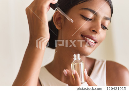 Woman Enjoying Skincare Routine with Serum for Glowing Healthy Skin 120421915