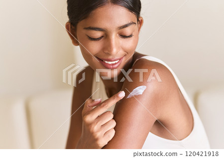Smiling Woman Applying Moisturizer for Healthy Glowing Skin Smiling Woman Applying Moisturizer for Healthy Glowing Skin 120421918