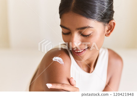 Woman Applying Moisturizer Smiling, Embracing Self-Care and Skin Wellness Woman Applying Moisturizer Smiling, Embracing Self-Care and Skin Wellness 120421948