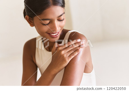 Woman Smiling While Applying Moisturizer for Healthy Glowing Skin Care Routine 120422050