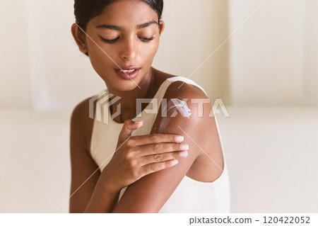 Woman Gently Applying Skincare Cream on Shoulder for Soft, Healthy Skin Woman Gently Applying Skincare Cream on Shoulder for Soft, Healthy Skin 120422052
