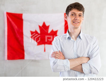 Young guy posing in front of Canadian flag 120422223