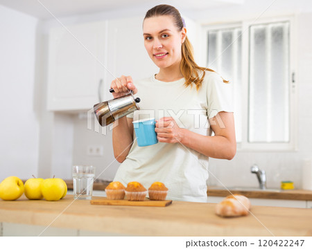 Woman pouring fresh coffee into mug 120422247