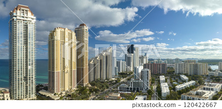High angle view of Sunny Isles Beach city with expensive highrise hotels and condo buildings on Atlantic ocean shore. American tourism infrastructure in coastal southern Florida 120422667