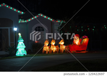Front yard with brightly illuminated Christmas decorations. Outside decor of florida family home for winter holidays Front yard with brightly illuminated Christmas decorations. Outside decor of florida family home for winter holidays 120422697