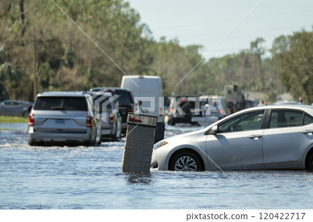 Flooded road in Florida after heavy hurricane rainfall. Evacuating cars and surrounded with water houses in suburban residential area Flooded road in Florida after heavy hurricane rainfall. Evacuating cars and surrounded with water houses in suburban residential area 120422717
