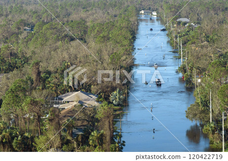 Flooded road in Florida after heavy hurricane rainfall. Aerial view of evacuating cars and surrounded with water houses in suburban residential area Flooded road in Florida after heavy hurricane rainfall. Aerial view of evacuating cars and surrounded with water houses in suburban residential area 120422719