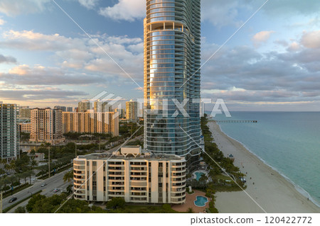 Expensive high-rise hotels and condos over sandy beachfront on Atlantic ocean shore in Sunny Isles Beach city at sunset. American tourism infrastructure in southern Florida Expensive high-rise hotels and condos over sandy beachfront on Atlantic ocean shore in Sunny Isles Beach city at sunset. American tourism infrastructure in southern Florida 120422772