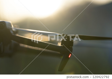 Drone with digital camera and fast rotating propellers flying ta 120422792