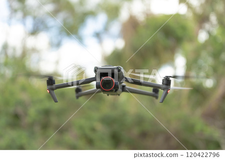 Drone aircraft with blurred fast rotating propellers and video camera flying in air Drone aircraft with blurred fast rotating propellers and video camera flying in air 120422796