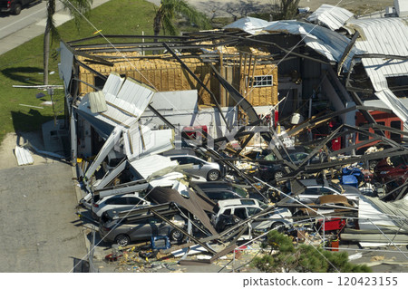 Destroyed by hurricane industrial building with damaged cars under ruins in Florida. Natural disaster and its consequences 120423155