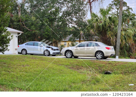 Dented car damaged after traffic accident parked on private home driveway Dented car damaged after traffic accident parked on private home driveway 120423164