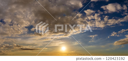 Colorful sunset sky with setting sun behind vivid orange and yellow clouds Colorful sunset sky with setting sun behind vivid orange and yellow clouds 120423192